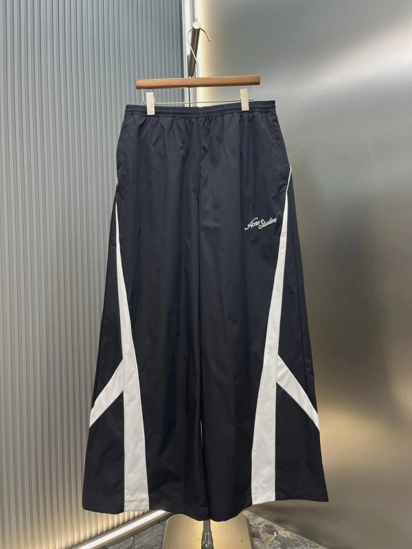 Acne Studios black athletic shorts with embroidered Ac logo and contrast piping, cut oversized