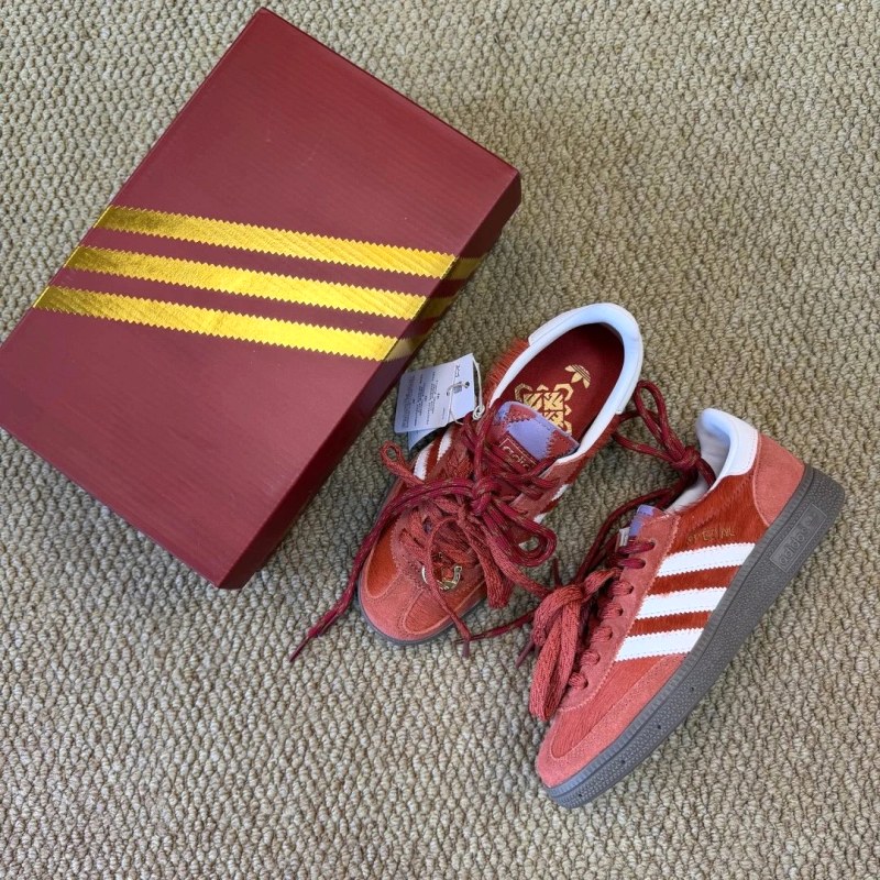 Adidas low-top lace-up sneaker in red with a rubber outsole and cushioning gel