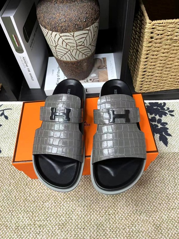 Hermes black slides with a cowhide upper and rubber outsole, in a casual couple-friendly cut