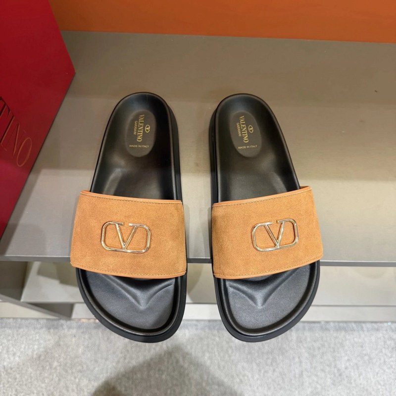 Valentino metal-logo flat slides in black, listed in EU 39–45 with calf-leather upper and rubber outsole